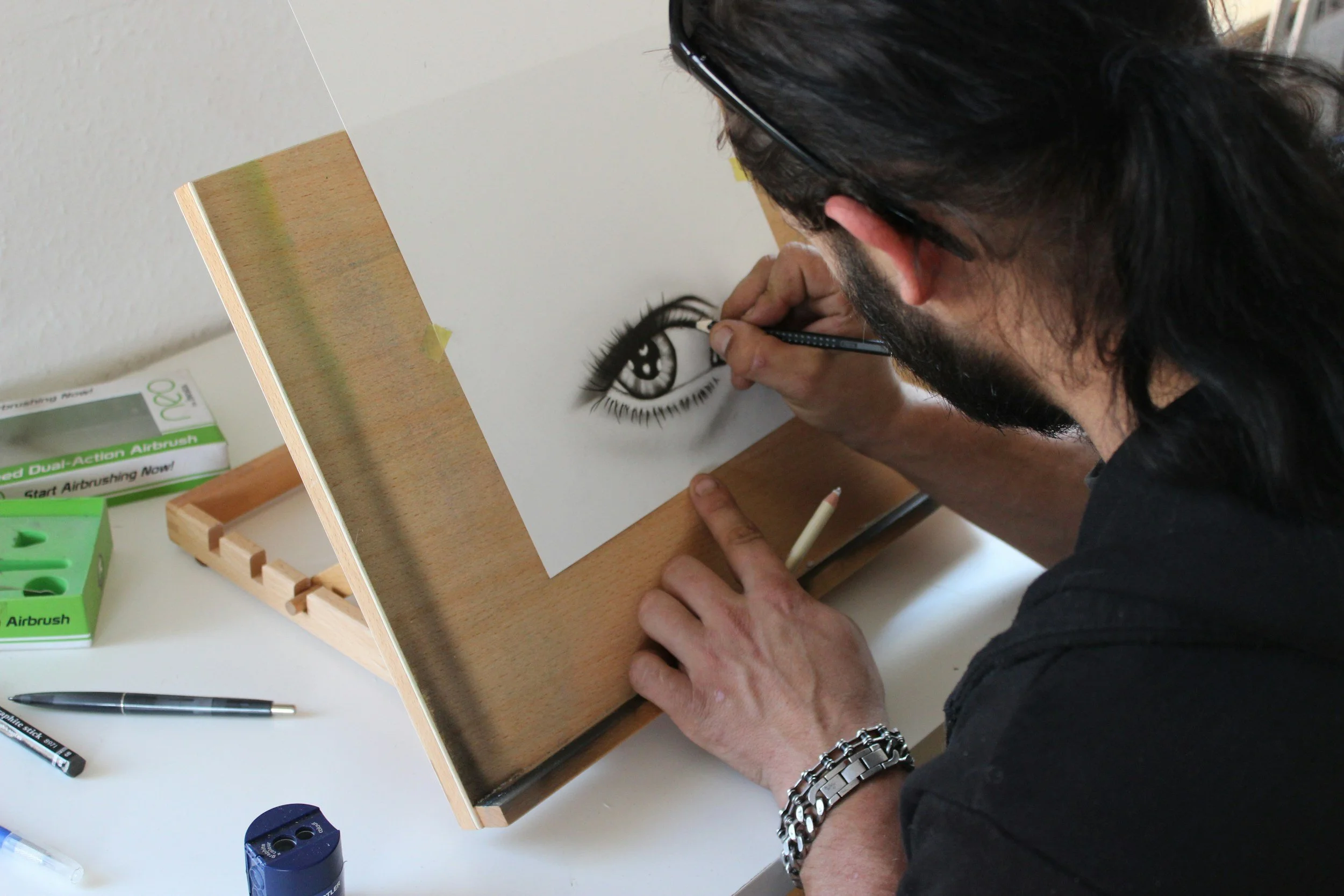 A man drawing an eye, with pencil