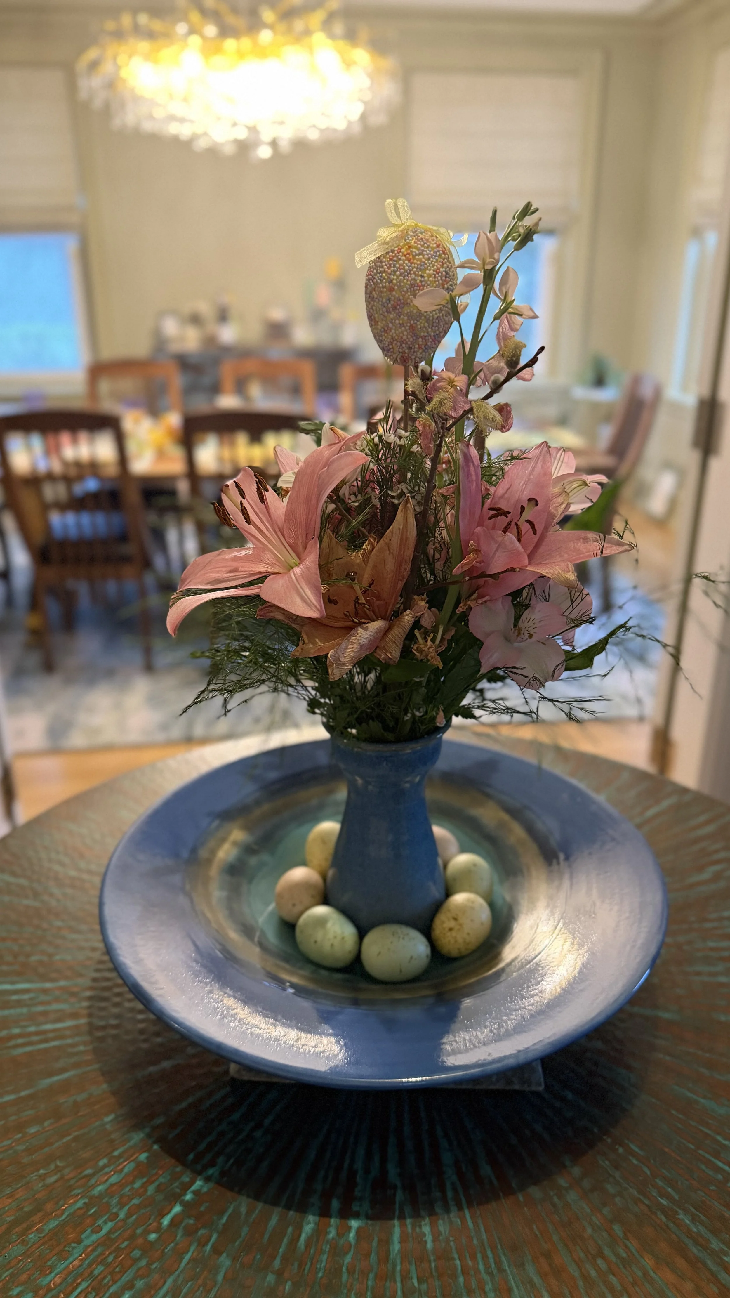 Flowers in the foreground, with an Easter table set in the background