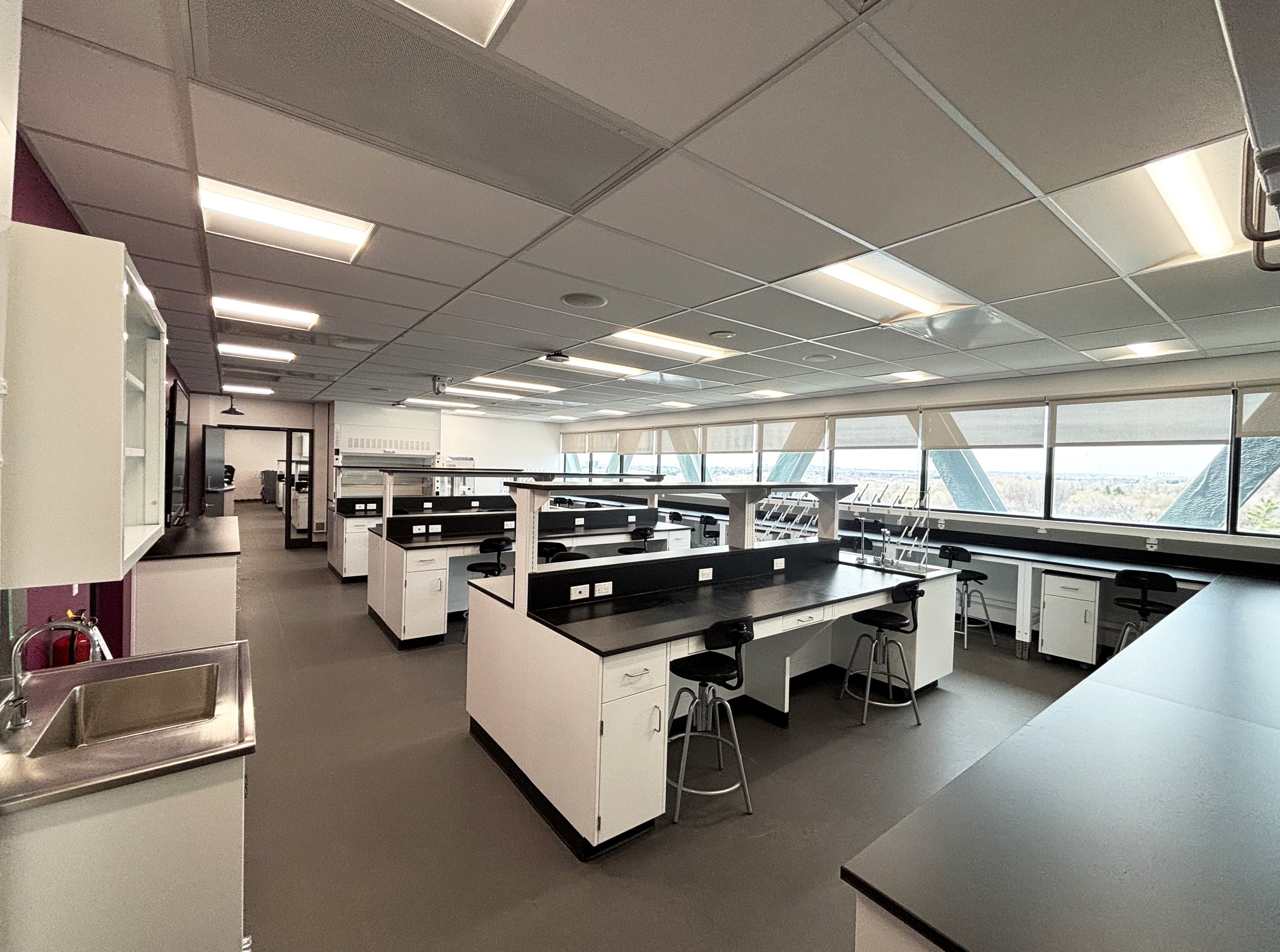 Benches, casework, chairs, and fume hoods, in a lab