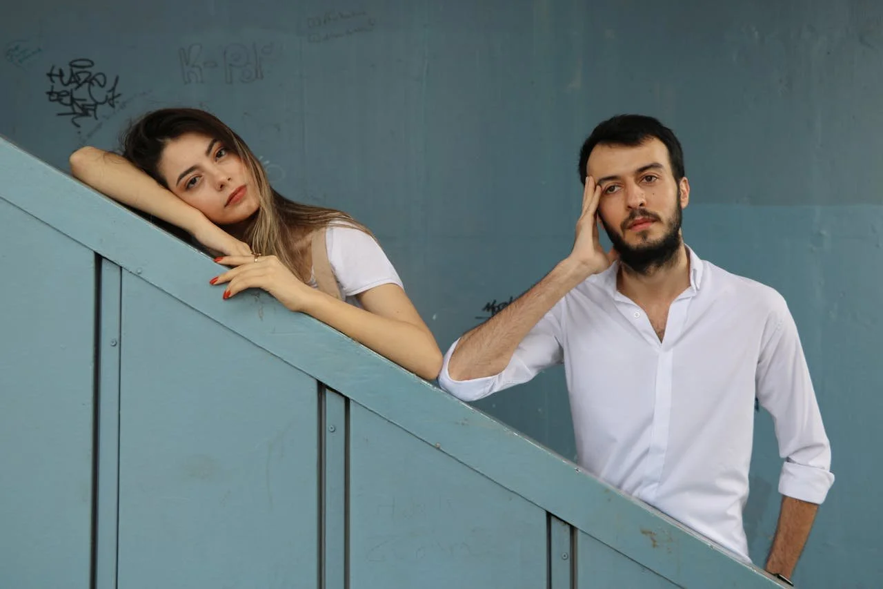 man-and-woman-standing-beside-green-wall