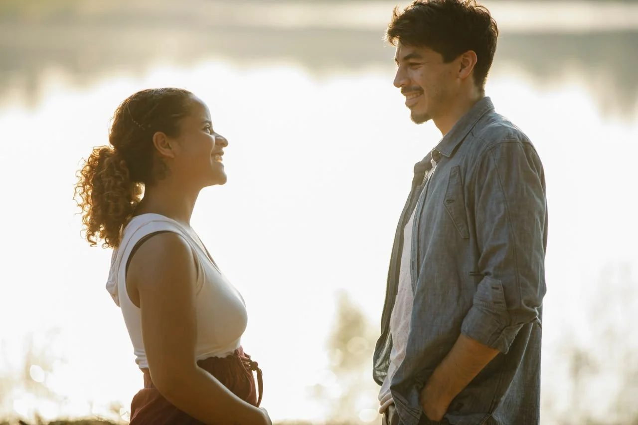 couple-looking-at-each-other-at-lakeside-during-date