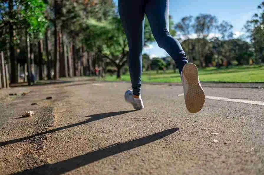 Close up of legs of a person jogging on a park path