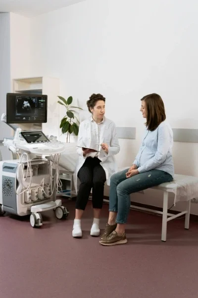 Pregnant woman talks with a doctor in an ultrasound room