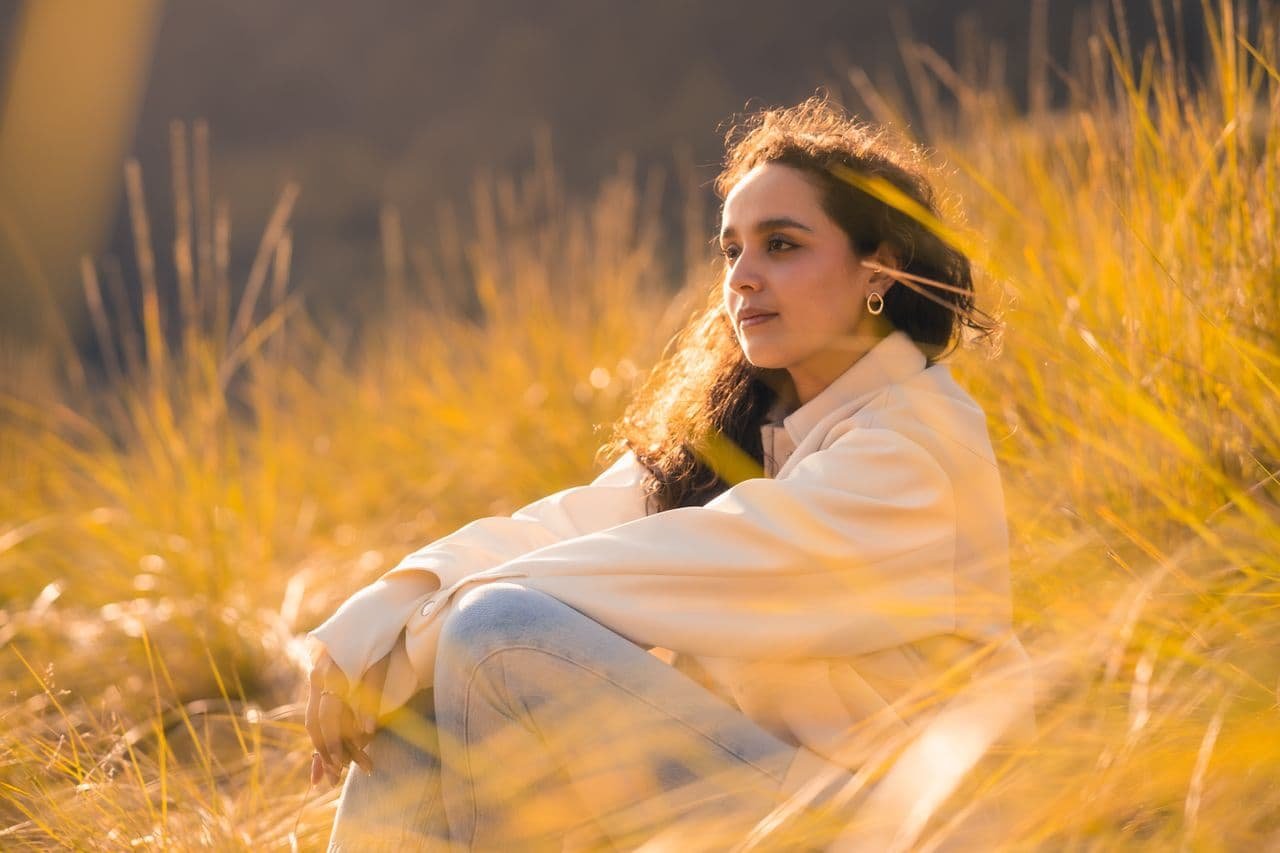 woman-relaxing-in-a-sunlit-field-at-dusk