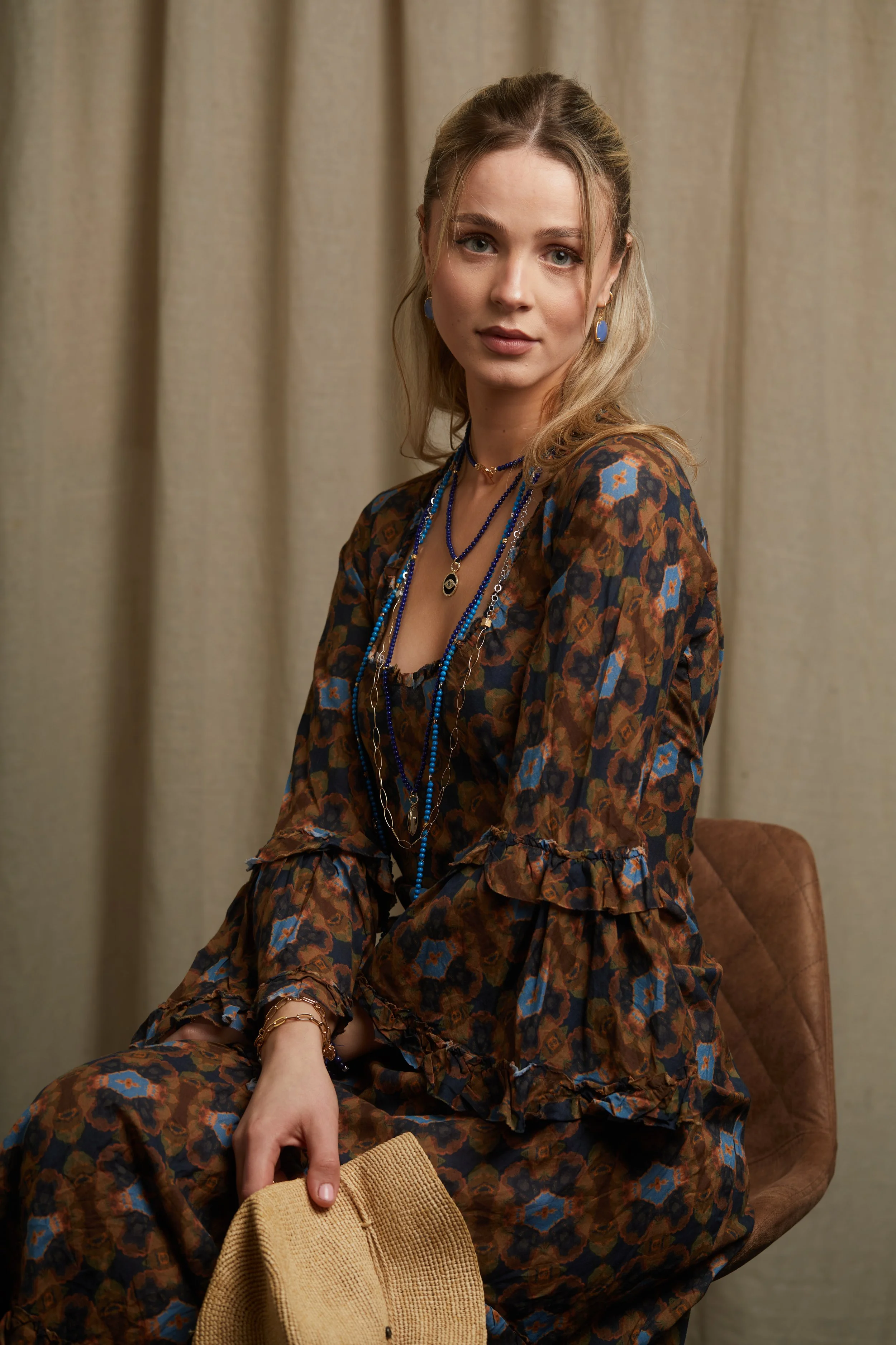 Maia , Milos Cushion, Brown Dress sitting with hat face forward.jpg