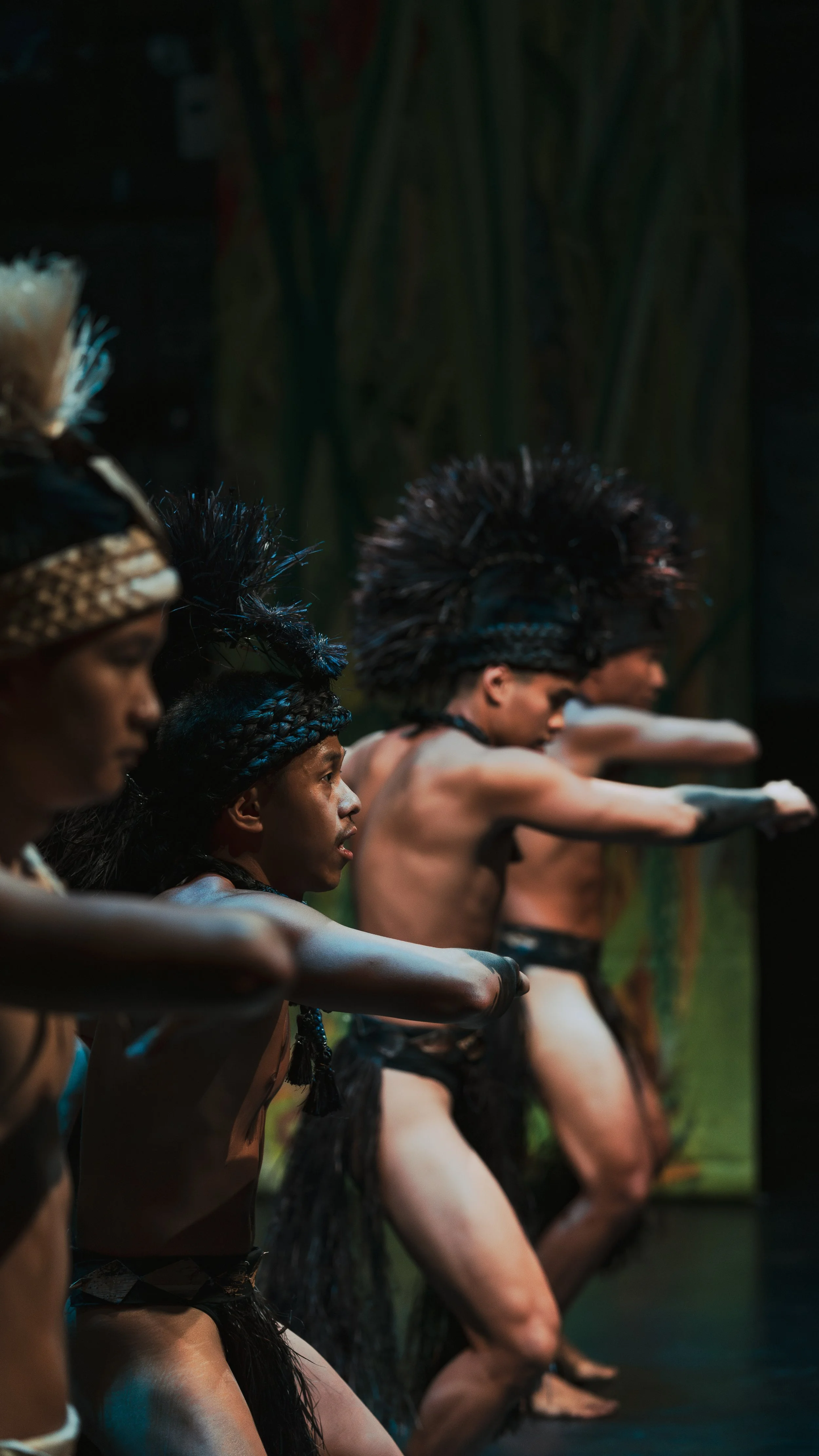 Men performing traditional Polynesian dance in cultural attire on stage