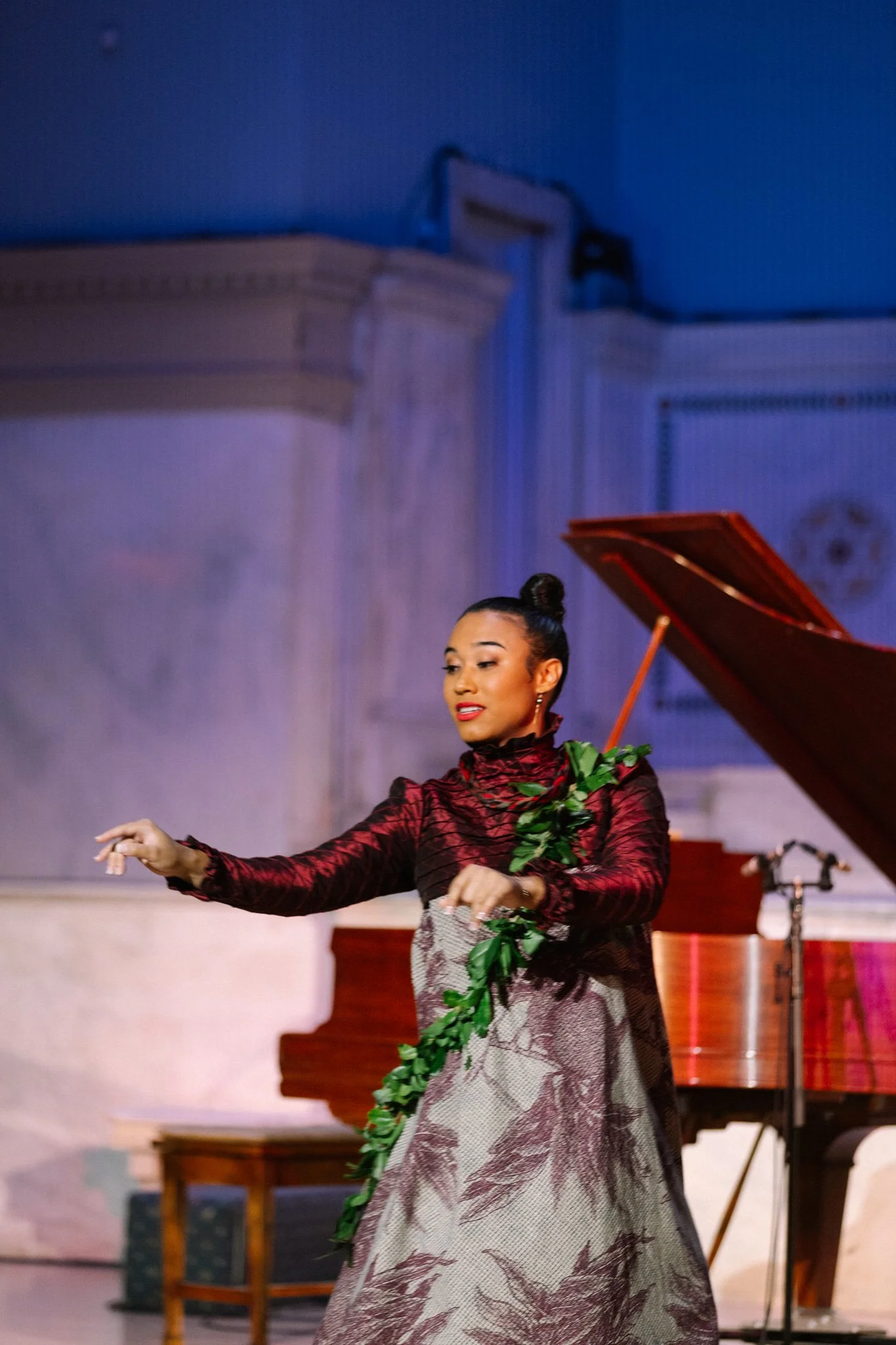 Group of dancers performing with white fabric on stage under green lighting.