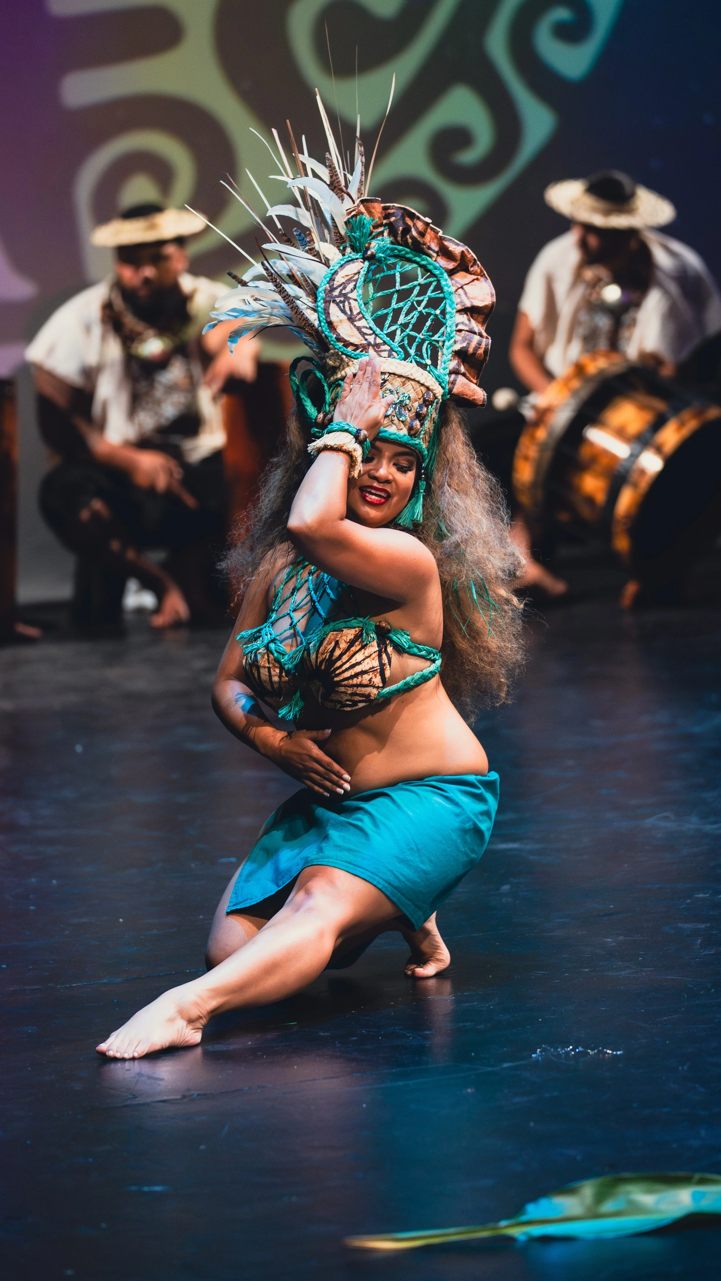Woman performing traditional dance with decorative headdress on stage.