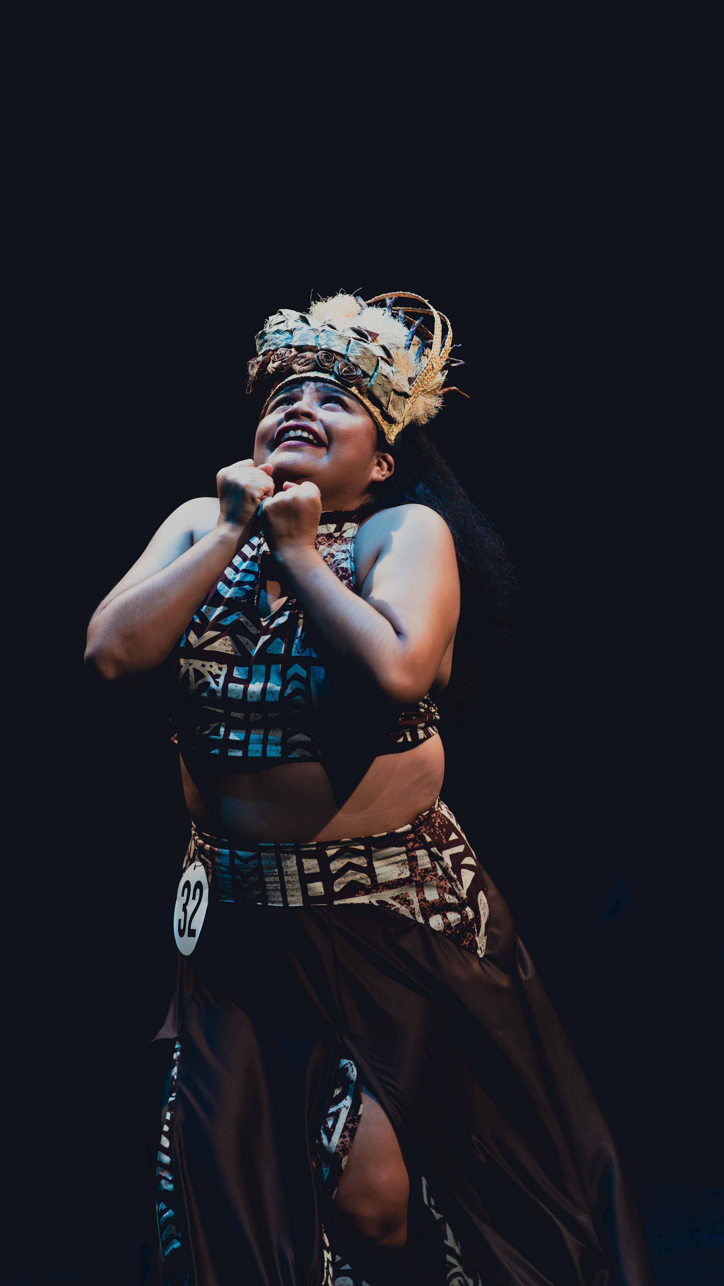 Woman in traditional Polynesian attire performing a dance.