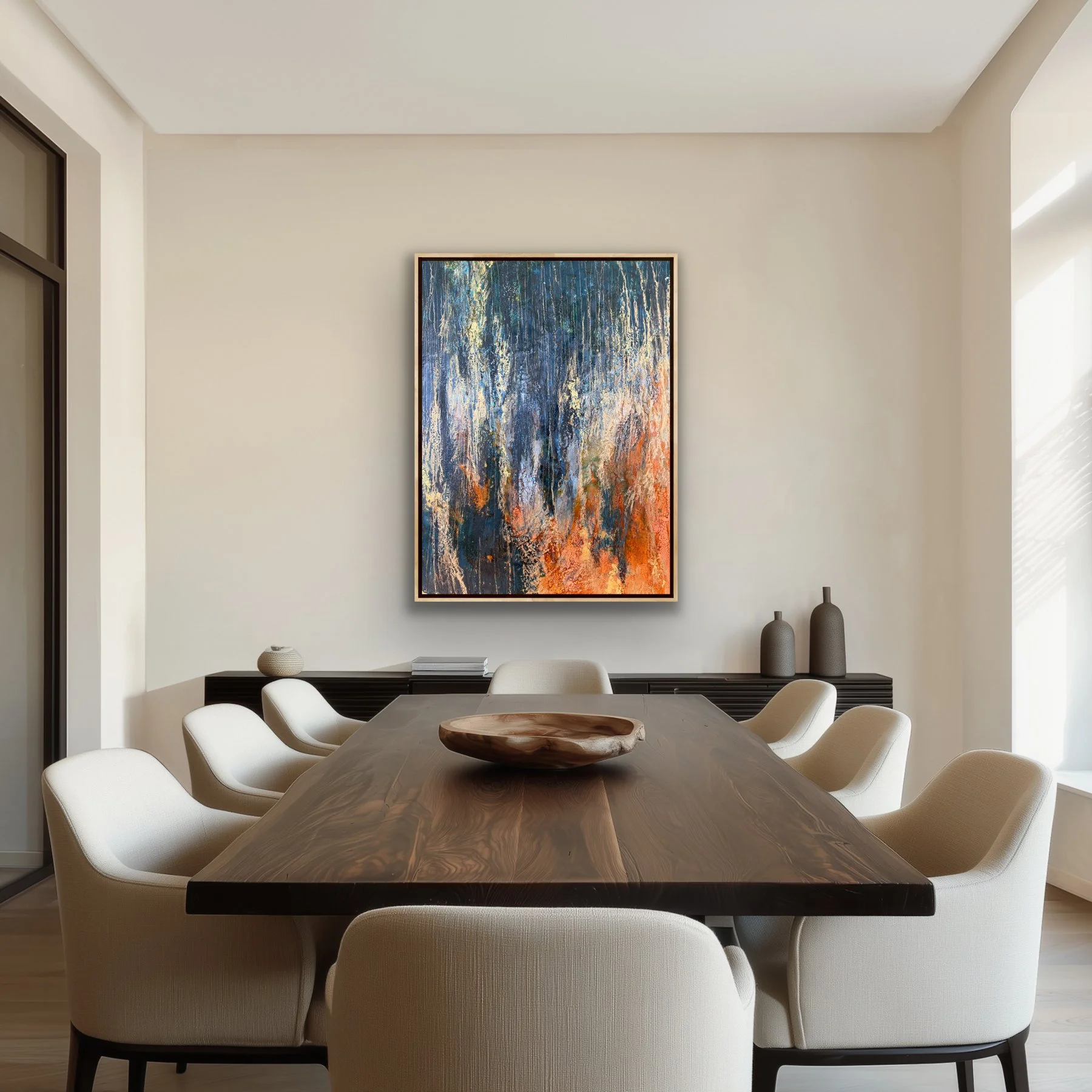 Original encaustic abstract landscape painting in a modern dining room, featuring layered beeswax, shellac burn, gold leaf, dark blue, cream, and fiery orange tones.