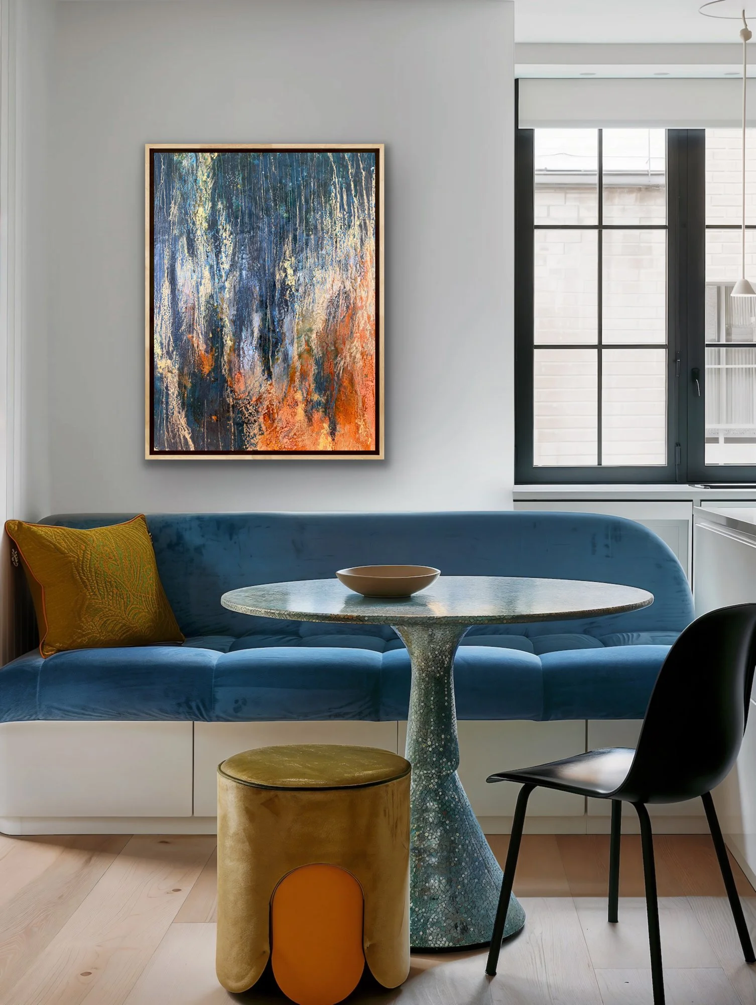 Nocturne in Gold original encaustic painting displayed in a modern dining nook with blue seating, dark blue tones, gold leaf, fiery orange accents, and contemporary abstract wall art.