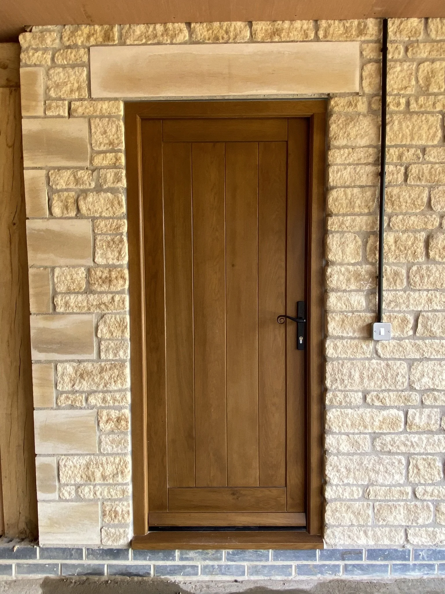 Tongue and groove paneled high performance oak door and frame with black hardware