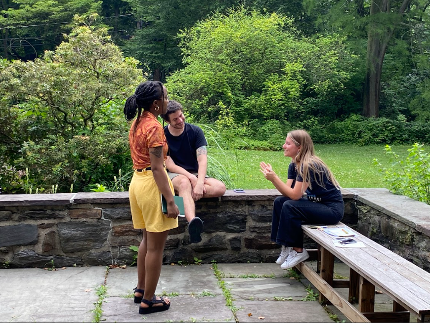    Three Fellows gather outside for a small group discussion.   