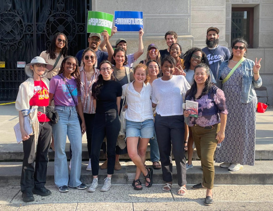    All Fellows, other Equity Fund staff, and Rabbi Julie Greenberg gather for a group picture outside of Philadelphia town hall after the POWER Interfaith kickoff rally. Two Fellows hold signs #PeoplesPlan and #EnvironmentalJustice.   