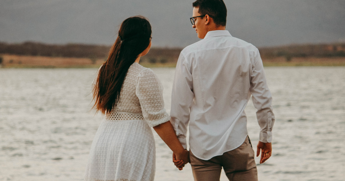Happy Couple holding hands overlooking water