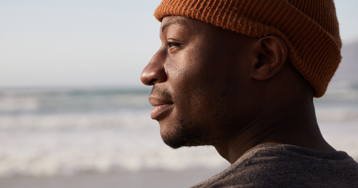 Black man looking thoughtful outside