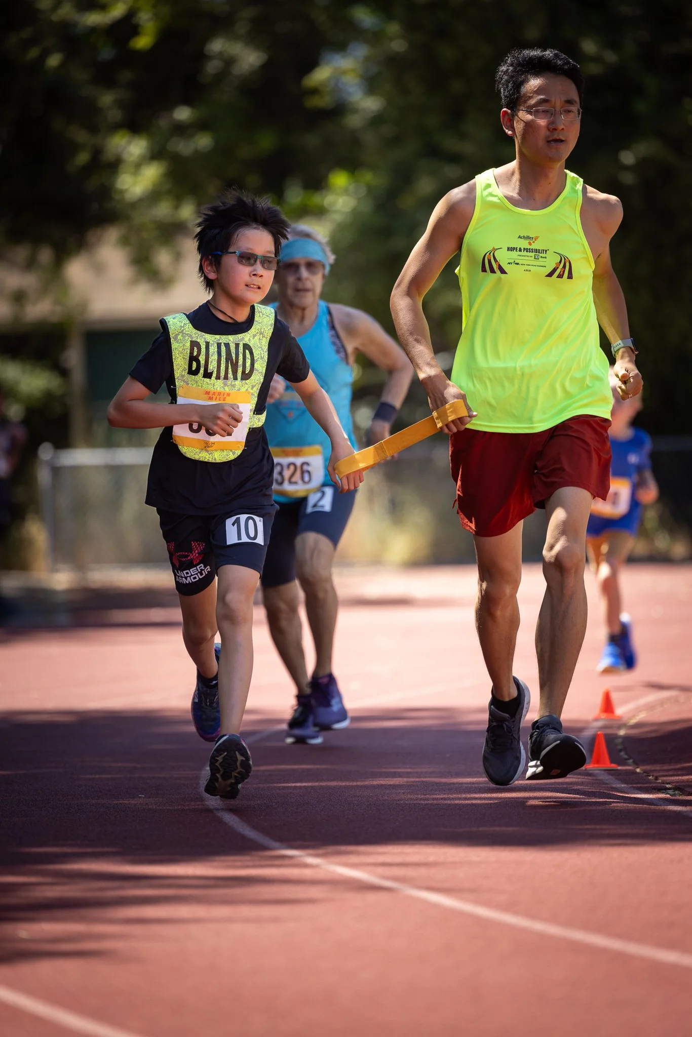 Young boy participating in a race, wearing a black shirt and shorts, with 