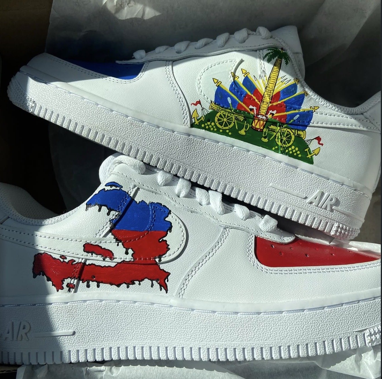 White sneakers with illustrations of a map of Costa Rica in red, blue, and black, and a medieval-style cart with flags and spears, painted on the side.