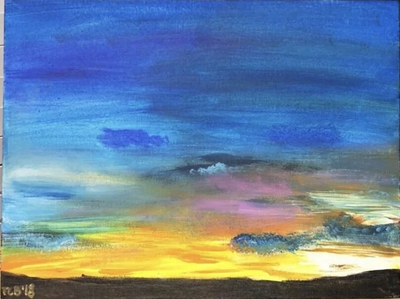 Colorful sunset sky over a dark horizon with vibrant hues of blue, purple, pink, orange, and yellow.