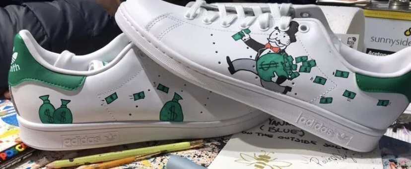 Custom white Adidas sneakers with green accents, featuring a cartoon bear holding a money bag and surrounded by dollar bills.