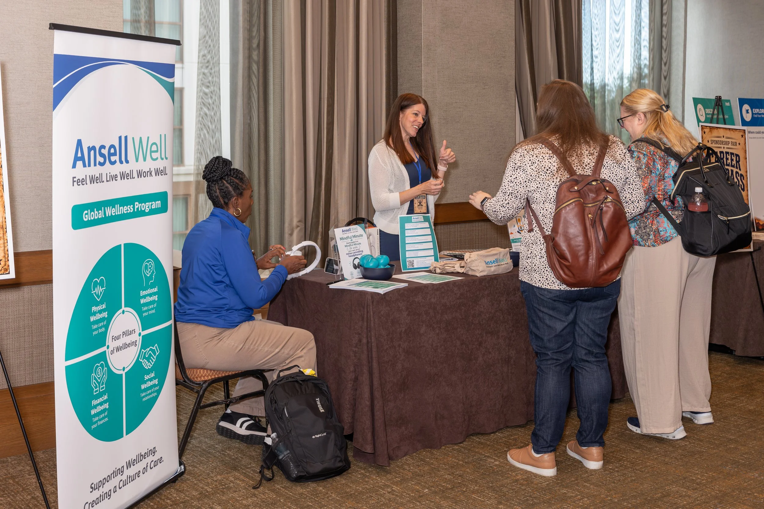 Attendees visit an Ansel Well Global Wellness Program booth at a workplace wellness fair.
