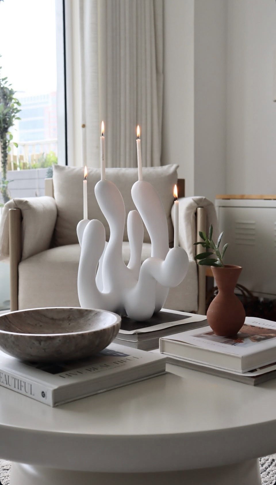 white candleholder on marble coffee table with books interior decor styling