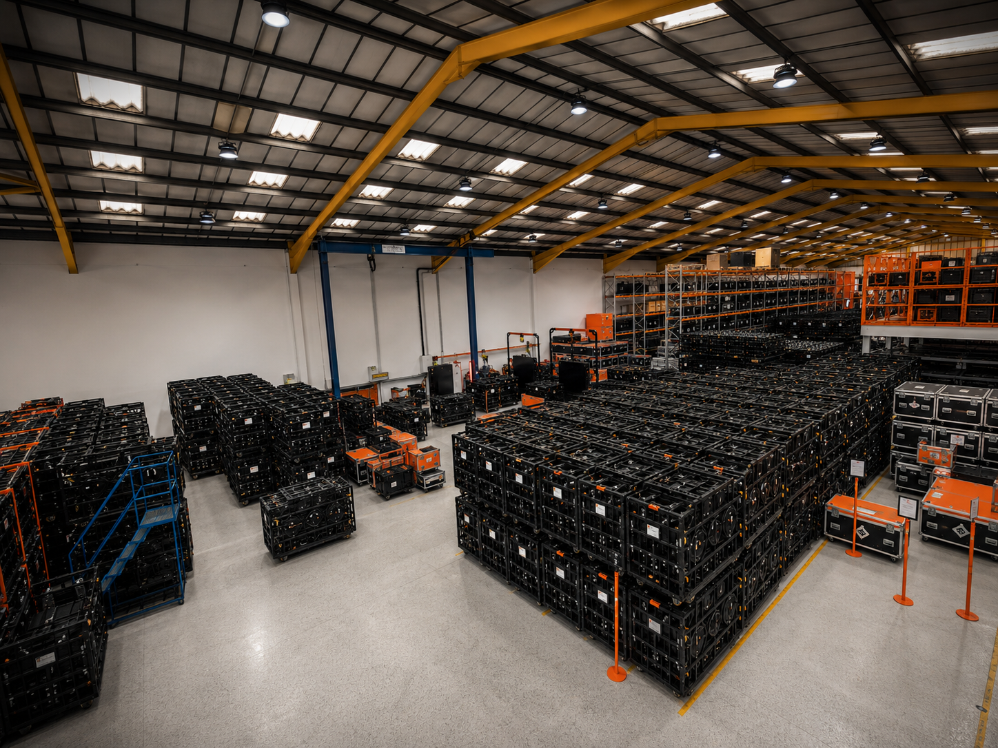 High-angle wide shot of the impeccably organised Universal Pixels equipment warehouse filled with organized rows of flight cases and LED screen dollies.