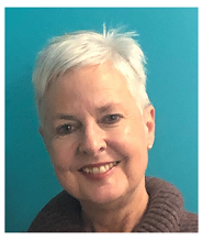 Close-up of a smiling woman with short white hair against a blue background
