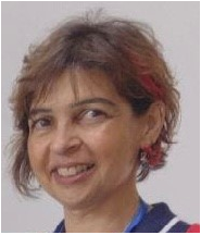 Close-up of a woman with short brown hair and red highlights, smiling at the camera.
