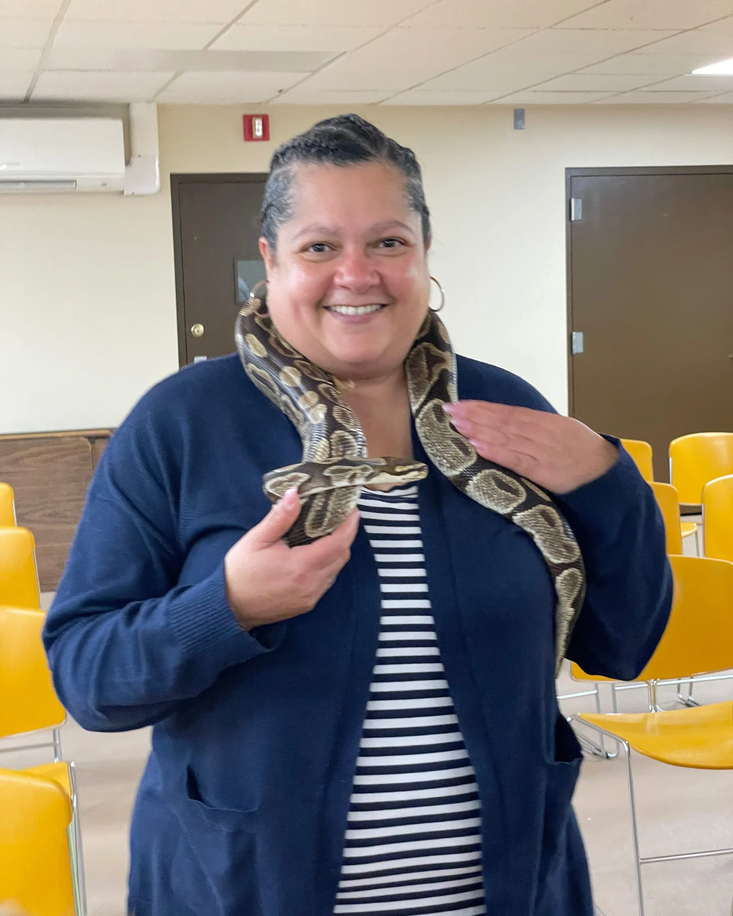 Library Staff holding a snake. 