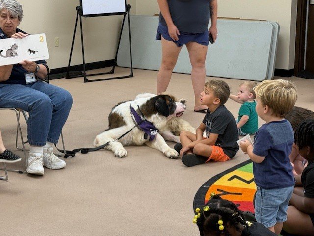 Children reading with a dog.