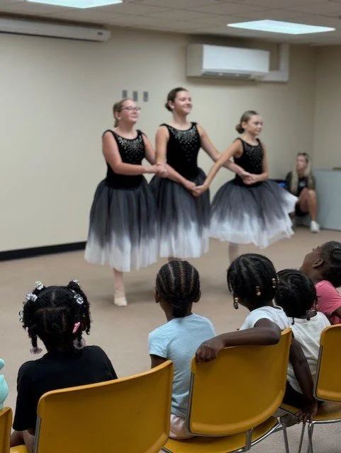 Three girls performing ballet.