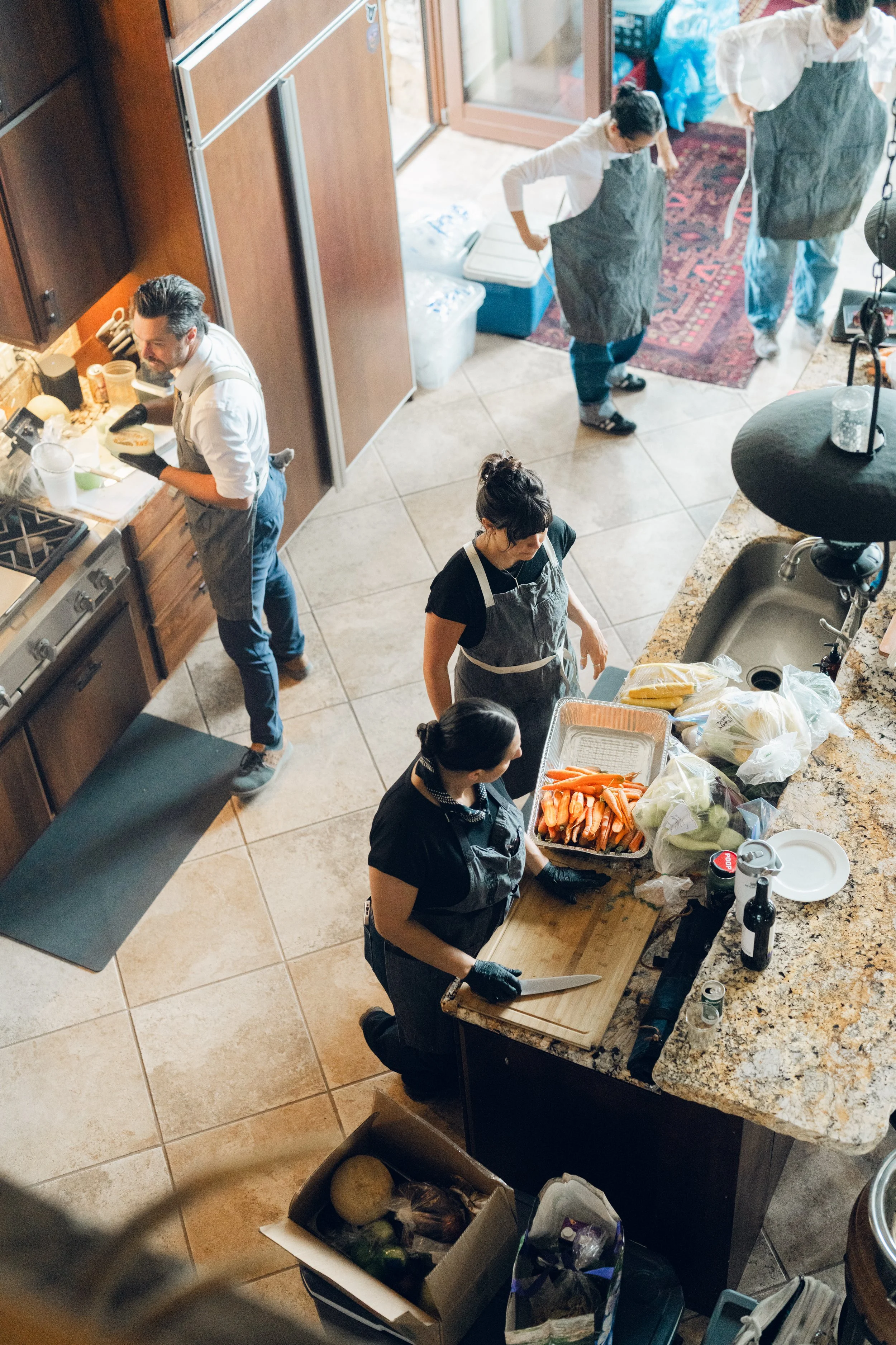 People preparing food in a kitchen, chopping vegetables, and cooking.