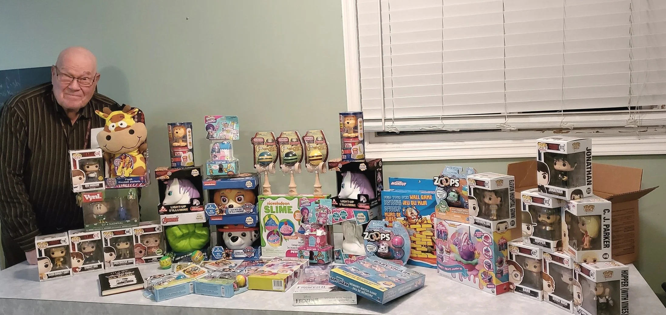 Robert -President of the Lumby Food Bank stands with $250 in donated toys!