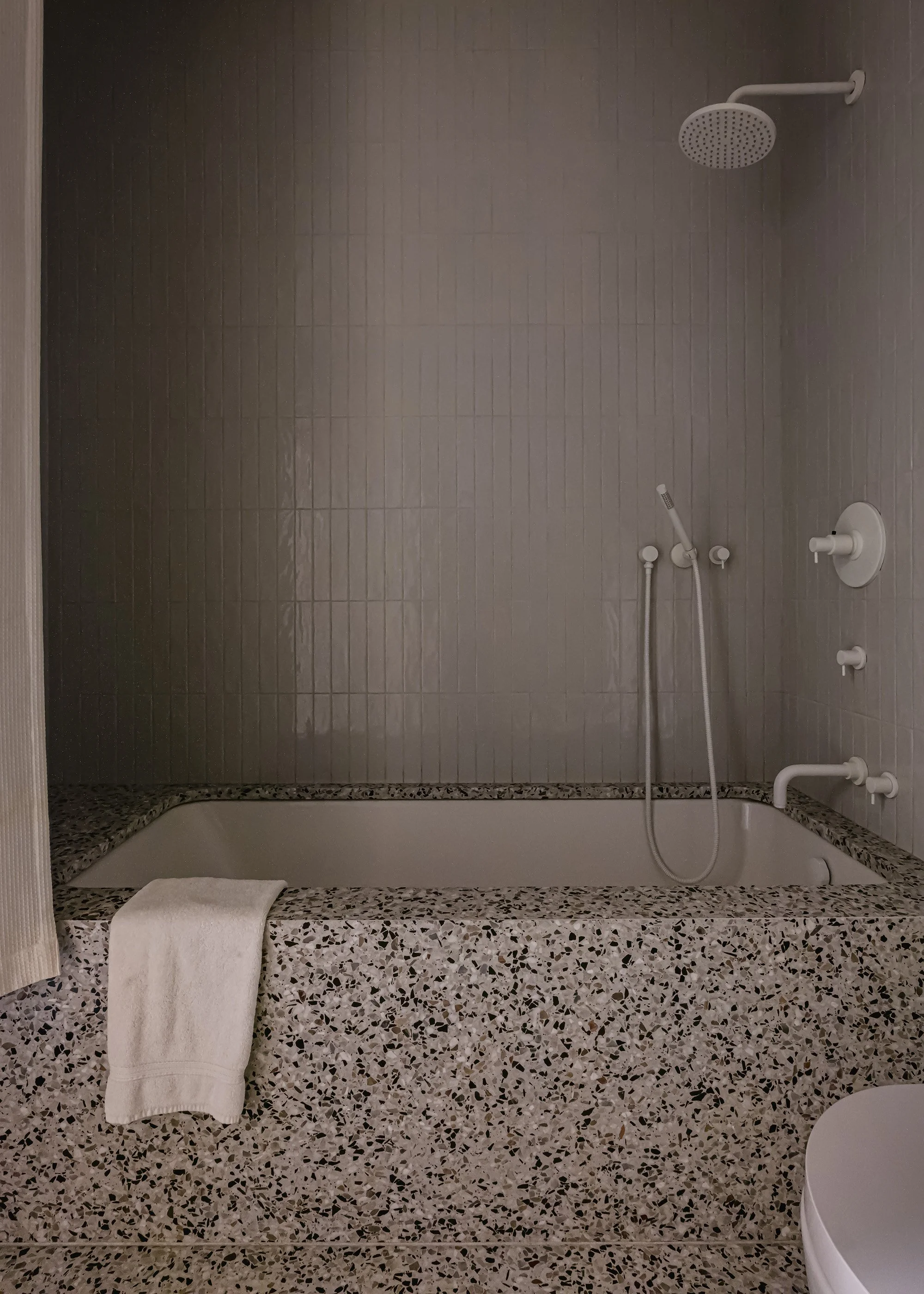 Terrazzo bathtub with undermount tub and white fixtures in kid's bathroom