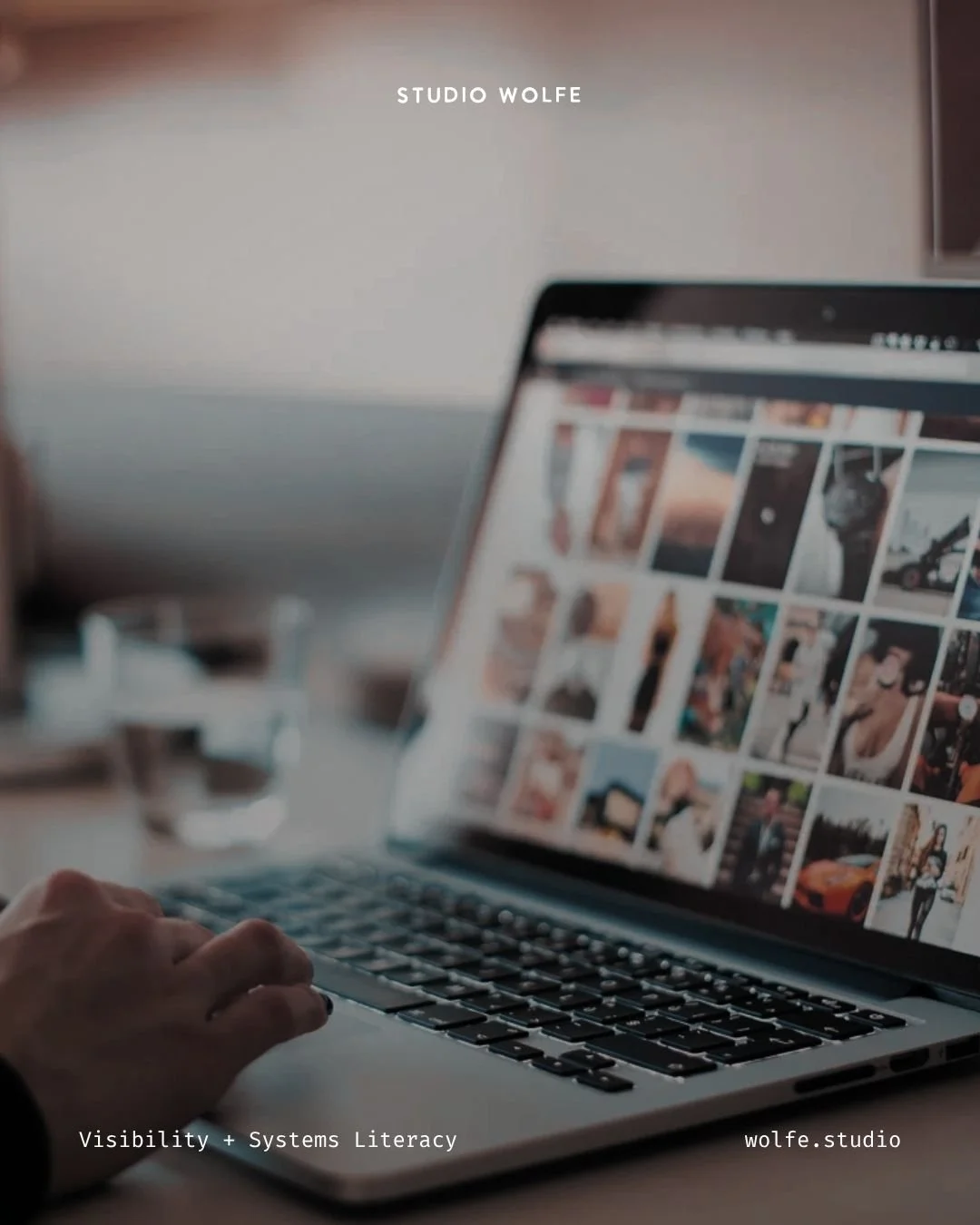 Laptop showing a grid of visual content while someone works beside it, suggesting digital visibility and organised online discovery.
