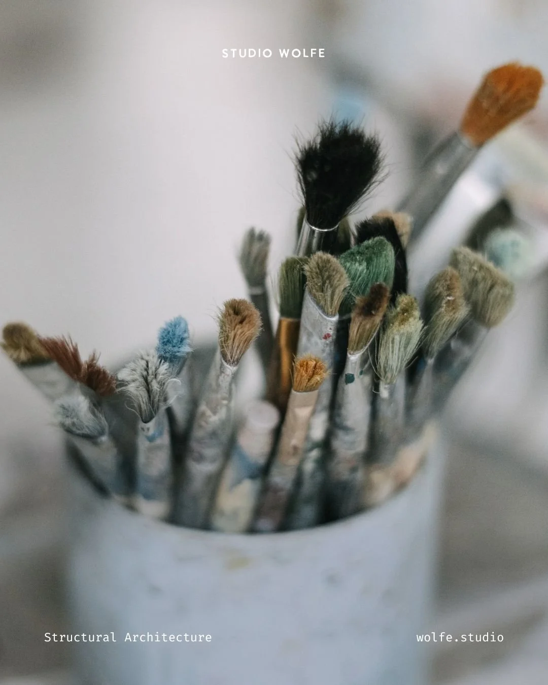 Close-up of assorted paintbrushes gathered in a pot, suggesting creative tools and varied modes of expression.