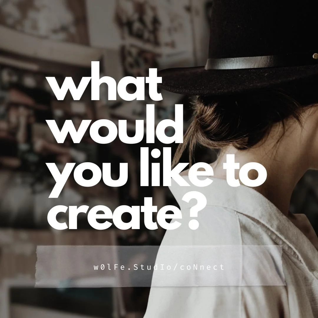 Michelle Wolfe standing against moodboard with images, notes and photographs, wearing brown hat and white cotton dress.