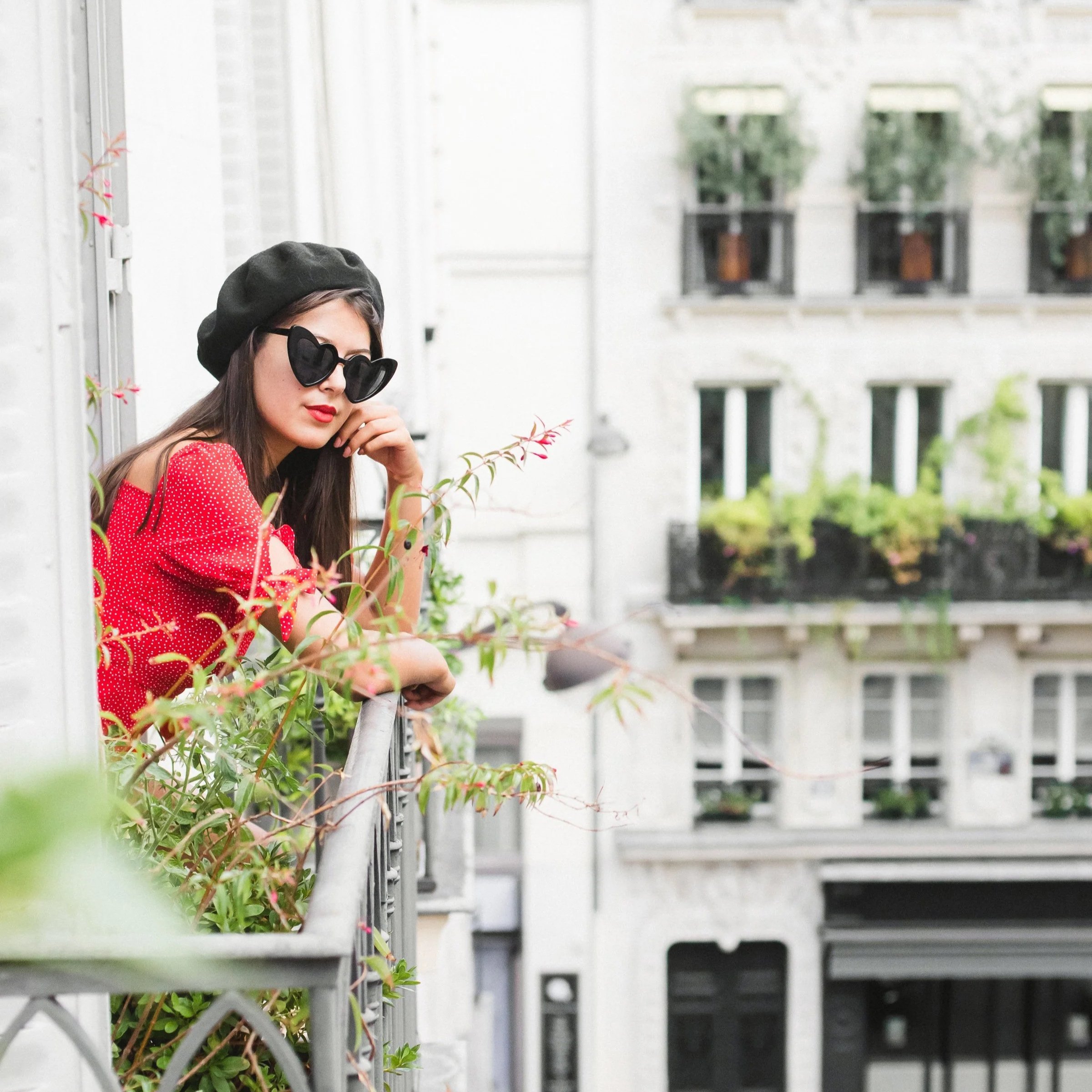 woman stands on a beautiful balcony in Paris
