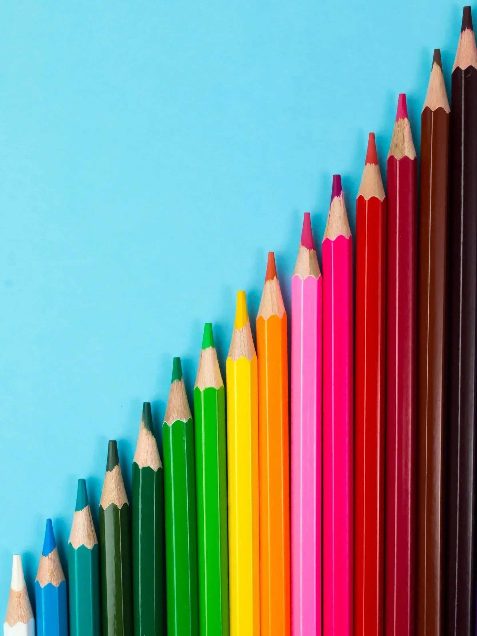 colored pencils on a bright light blue background