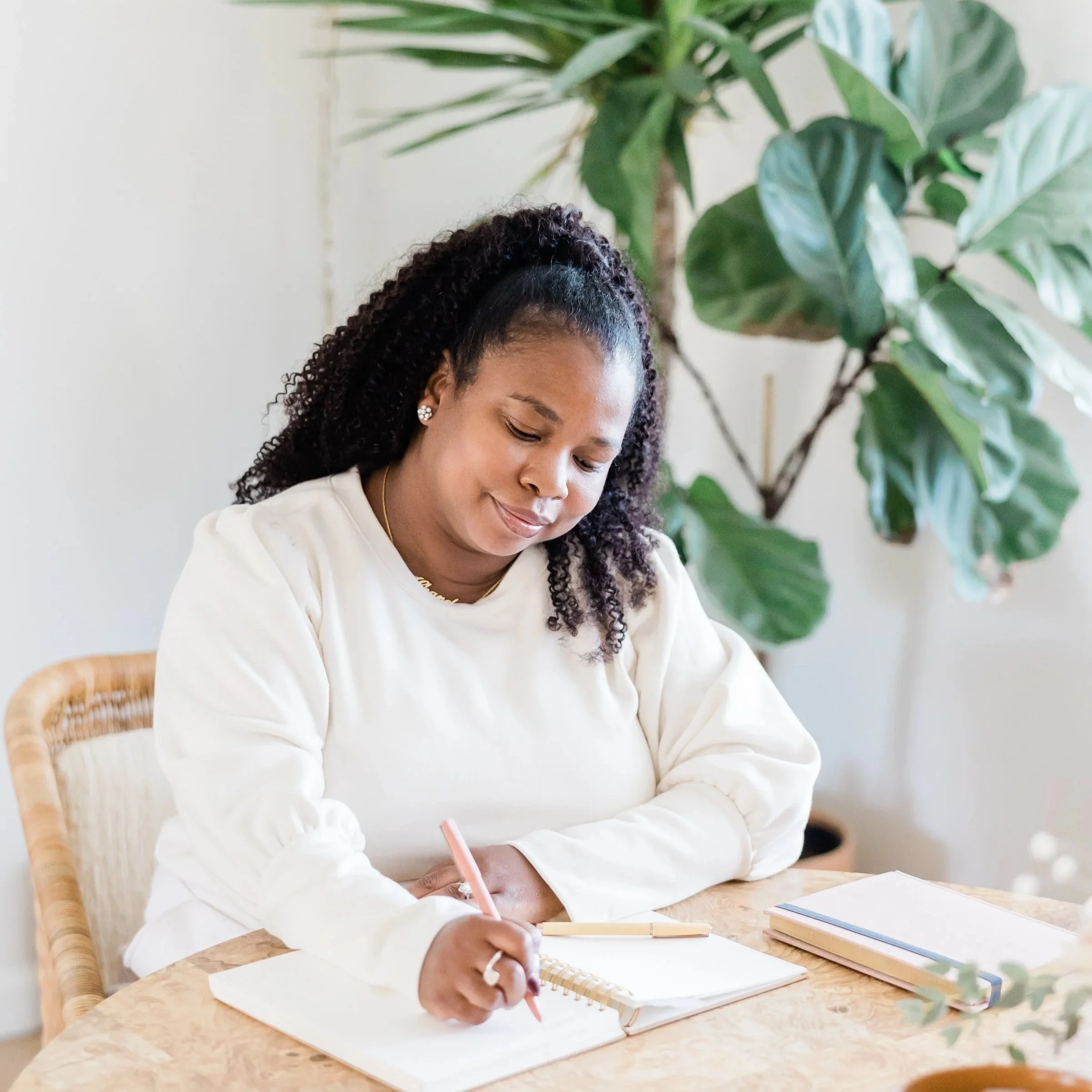 woman sits in a chair planning her schedule to succeed