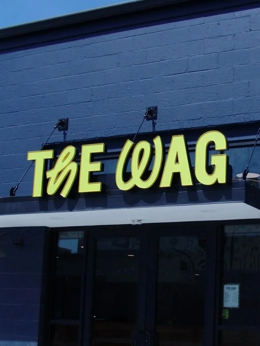 Green letter set reading "The Wag" mounted to the side of blue building, created by Brite Line Signs in Columbus, Ohio