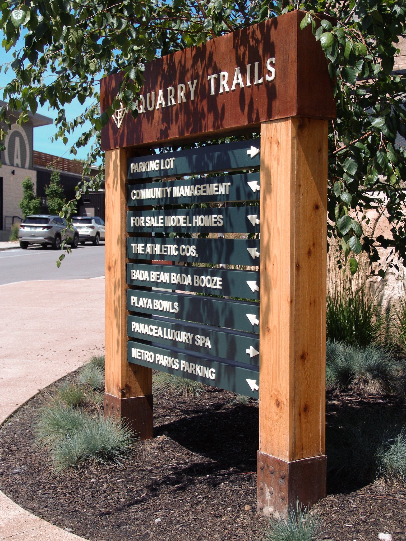 Wood monument sign reading "Quarry Trails" sits beneath a tree. Created by Brite Line Signs in Columbus, Ohio