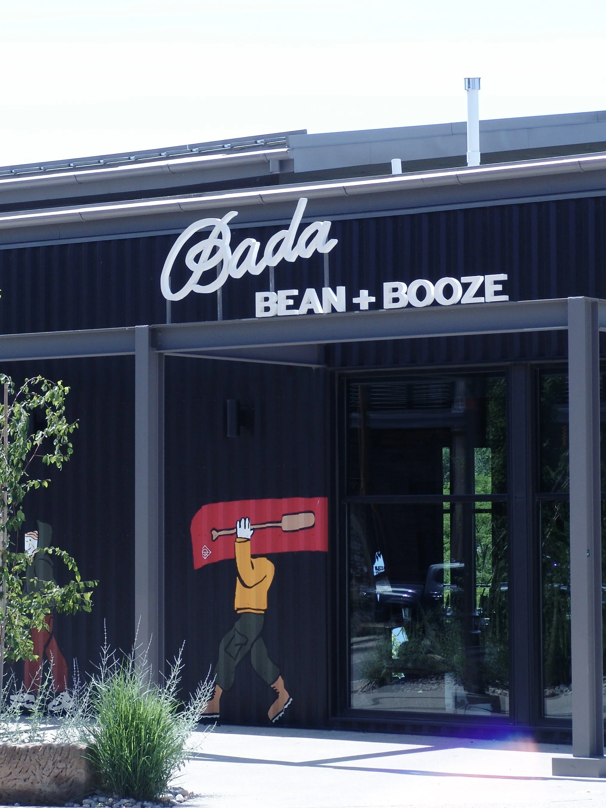 White letter set reading "Bada Bean + Booze" hangs over doorway. Created by Brite Line Signs in Columbus, Ohio