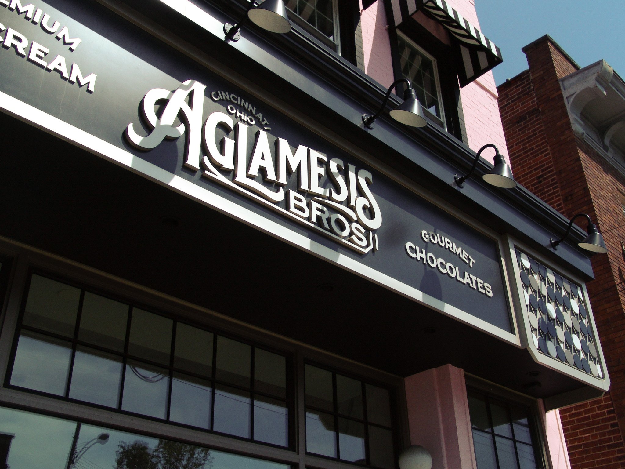 Sign reading "Aglamesis Bros" on a pink building. Sign created by Brite Line Signs in Columbus