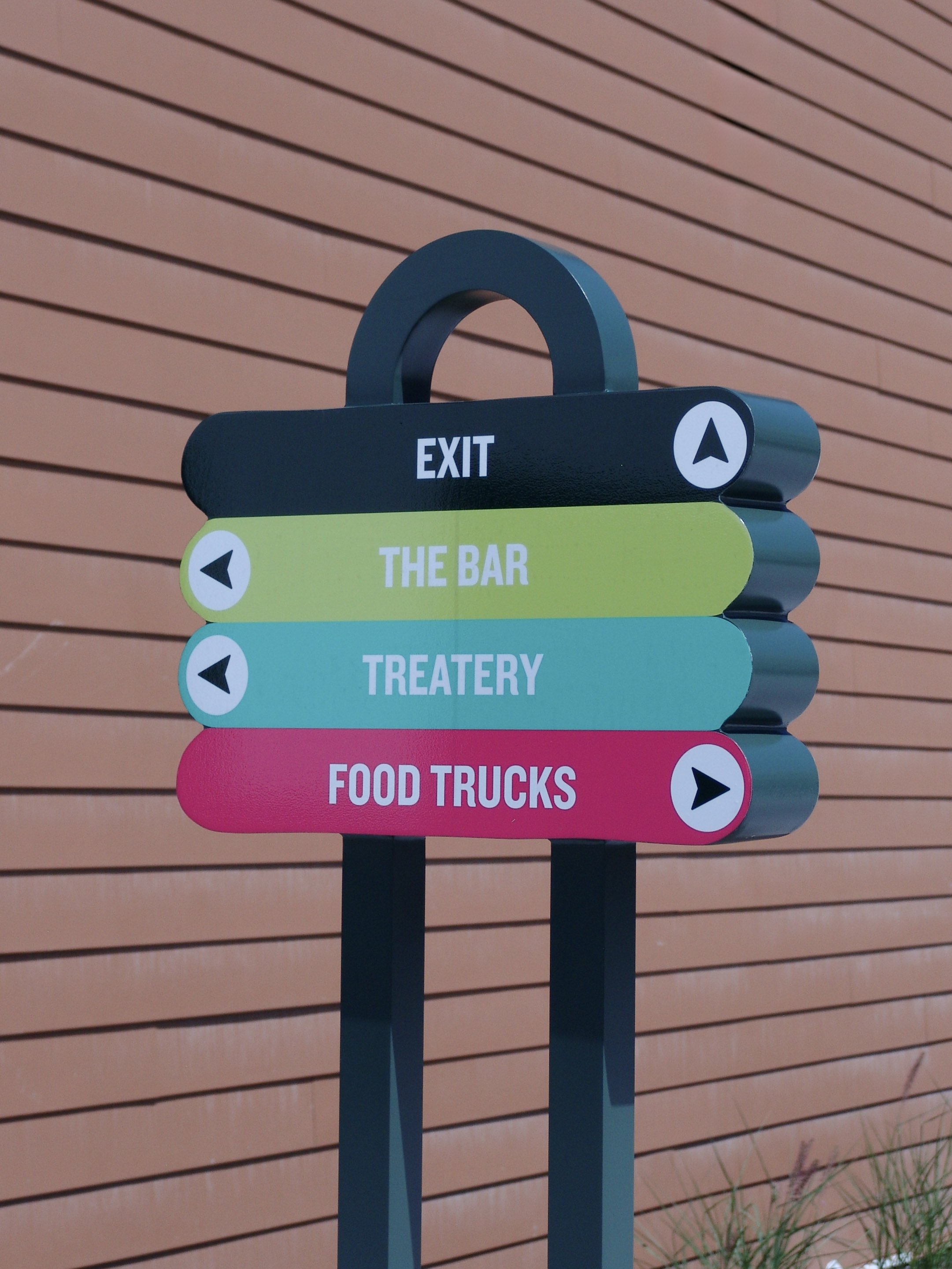 Dog tag shaped navigation sign in front of wood wall, created by Brite Line Signs in Columbus, Ohio