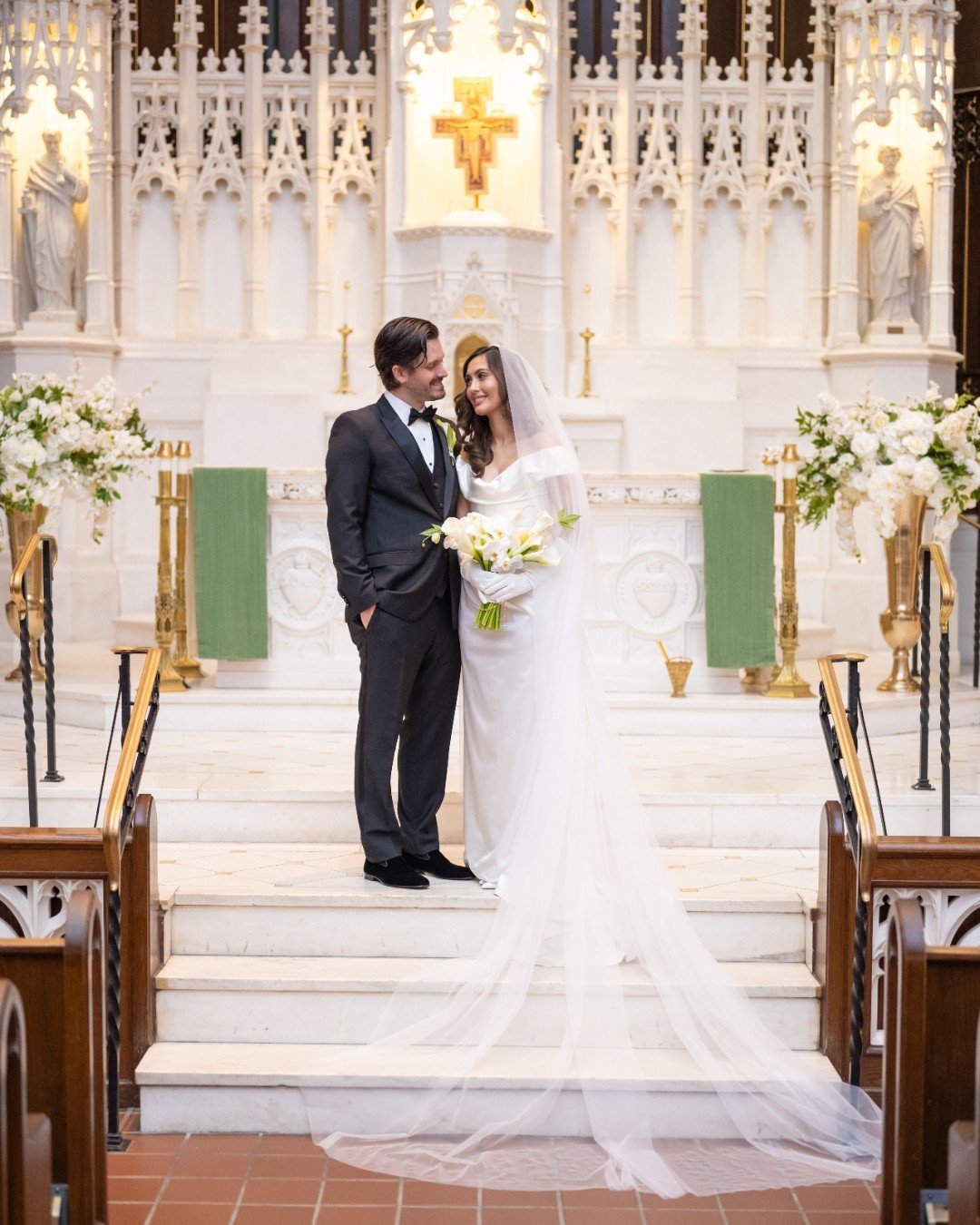 Surrounded by breathtaking cathedral architecture and timeless white florals, C + R shared a moment together just after their most special moment. C carried a sleek white calla lily bouquet, a classic choice that perfectly complemented the elegance o