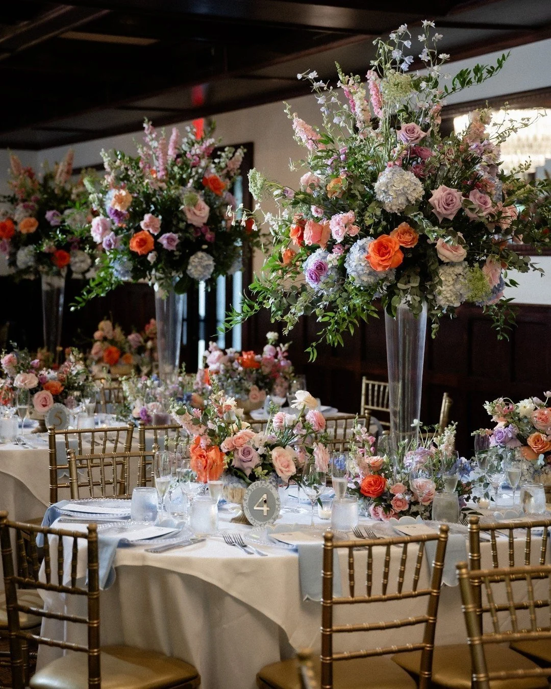 An evening layered in color, texture, and intention. Where every bloom was placed with purpose and every detail told a story.

From elevated garden-style centerpieces rising above soft blue linens and gold chiavari chairs, to an abundant, meadow-insp