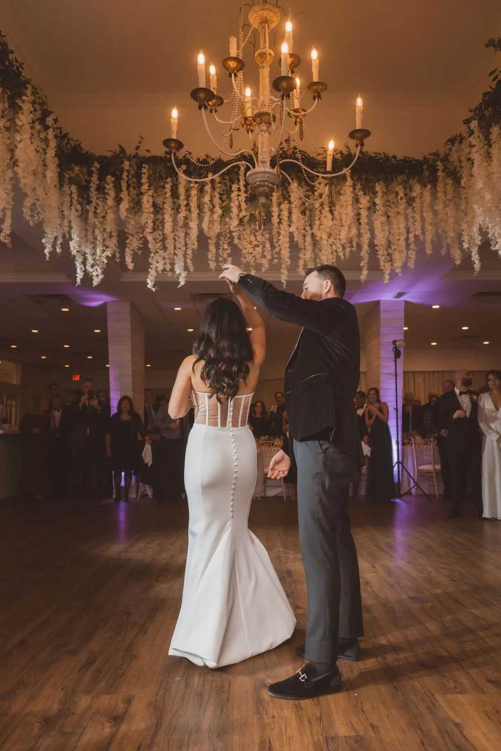 A newly wed bride and groom dancing under a ceiling of flowers
