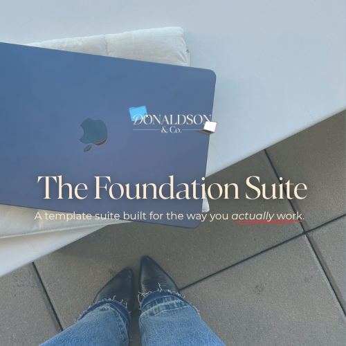 An open MacBook laptop with a sticker that reads "DONALDSON & CO." resting on a white table. The person taking the photo is wearing black shoes and blue jeans, standing on a tiled floor.